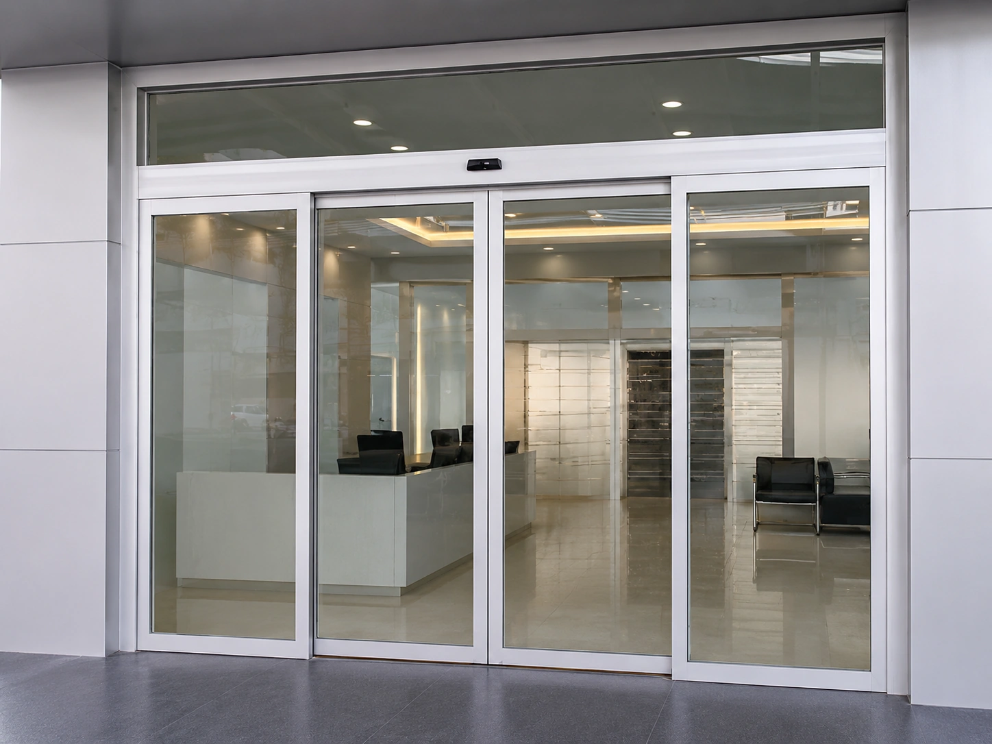 Progettazione di ingressi commerciali con porte scorrevoli automatiche in vetro.